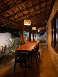 a wooden table and chairs under a wooden ceiling at Casa Cris in Itaúnas