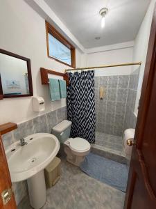 a bathroom with a sink and a toilet and a shower at Hotel Witttmer in Puerto Velasco Ibarra