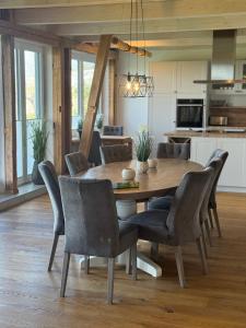a kitchen and dining room with a wooden table and chairs at Lütt Marschkieker in Langenhorn