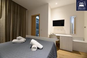 ein Schlafzimmer mit Bett, Schreibtisch und Fernseher in der Unterkunft Area Sud in Canicattì