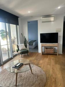 a living room with a couch and a tv and a table at Centrepoint Units Heidelberg in Melbourne