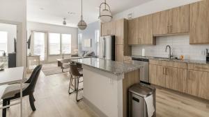 a kitchen with wooden cabinets and a counter top at Landing Beautiful Studio Gym Pool in Addison