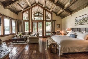 a bedroom with a large bed and a living room at Blanket Bay in Glenorchy +36 photos