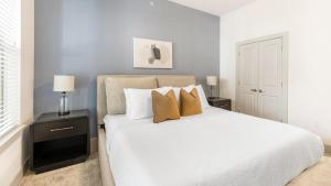 a bedroom with a white bed with two pillows at Landing Beautiful Studio Gym Pool in Addison +49 photos