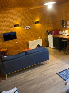 a living room with a blue couch and a table at Studio vintage in Parthenay