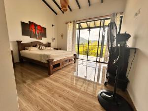a bedroom with a bed and a large glass door at Finca Villa AlCon - Hostel in Pereira +57 photos