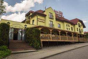 a yellow building with a staircase in front of it at Restauracja -Zajazd trzech braci in Cieszyn