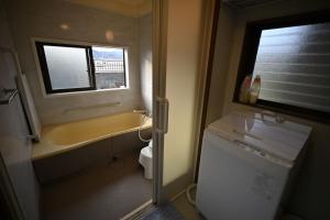 a bathroom with a sink and a toilet and a window at The Nomad Inn Yugejima in Kami-yuge +23 photos