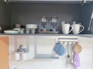 a kitchen with cups and utensils on a shelf at 대구 동성로 스타비앤비 in Hyomoktong-Ilgu