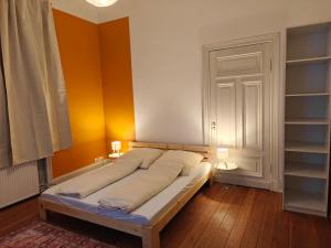 a bed in a room with orange and white walls at Zentrales & gemütliches Zimmer in Lübeck