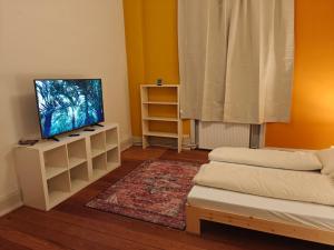 a living room with a flat screen tv on a white cabinet at Zentrales & gemütliches Zimmer in Lübeck