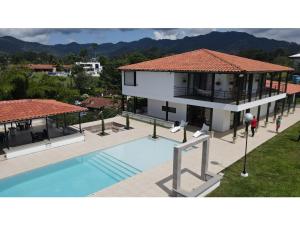 a house with a swimming pool in front of it at Finca Villa AlCon - Hostel in Pereira