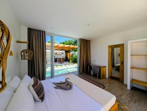 a bedroom with a large bed and a large window at Villa Nindot - Private pool villas - Adults only in Siquijor +26 photos