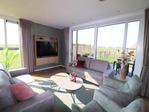 a large living room with couches and a tv at Luxury waterfront villa in Leons