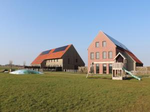 a large barn with a playground and a building at Luxury waterfront villa in Leons