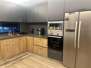 a kitchen with stainless steel appliances and wooden cabinets at Finca Villa AlCon - Hostel in Pereira