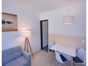 a room with a table and a chair and a table and a lamp at Studio Bernhard mit Pool und Sauna in Freyung