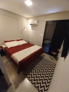 a bedroom with a bed and a rug in it at Prime Flat Palladium Mar & Piscina in São Vicente +41 photos