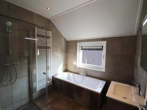 a bathroom with a tub and a sink and a shower at Luxury waterfront villa in Leons +31 photos