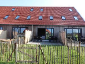 a house with a red roof and a wooden fence at Luxury waterfront villa in Leons