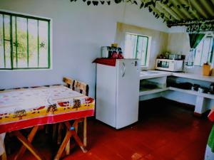 a kitchen with a refrigerator and a table in it at Finca la Riverita in Sutamarchán