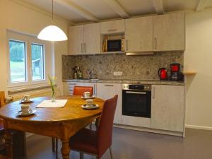 a kitchen with a wooden table and a dining room at Sugar Farm Weideblick in Sankt Georgen im Schwarzwald