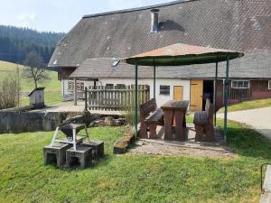 a picnic shelter with two benches and a table at Sugar Farm Weideblick in Sankt Georgen im Schwarzwald +22 photos