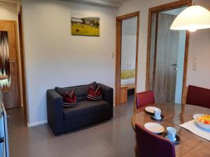 a living room with a couch and a table at Sugar Farm Weideblick in Sankt Georgen im Schwarzwald