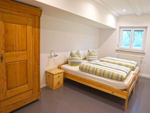 a bedroom with two beds and a wooden cabinet at Sugar Farm Weideblick in Sankt Georgen im Schwarzwald
