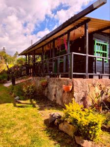 a house with a stone wall in front of it at Finca la Riverita in Sutamarchán