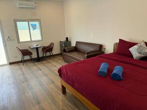 a bedroom with a bed and a couch and a table at Roomz at Rawai in Ban Saiyuan (1)