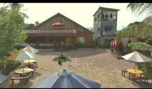 a patio with tables and umbrellas in front of a building at Bomi Bar in King Faro