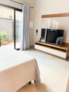 a bedroom with a flat screen tv and a bed at Studio moderno no centro de vinhedo in Vinhedo