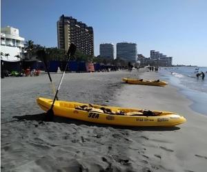 a yellow kayak on a beach with a paddle at Chazze House in Santa Marta