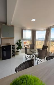 a kitchen and dining room with a table and chairs at Apto Rosas| 3Q, todo Climatizado, Prox das Termas in Piratuba