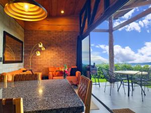 a dining room with a table and chairs and a couch at Private Mountain Cabin with Garden Views in Zarcero