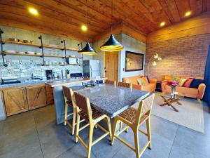 a kitchen and living room with a table and chairs at Private Mountain Cabin with Garden Views in Zarcero
