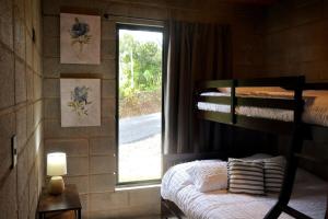 a bedroom with a bunk bed and a window at Private Mountain Cabin with Garden Views in Zarcero