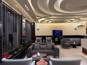 a lobby with couches and tables and a coffered ceiling at TAJ Hotel in Aqaba