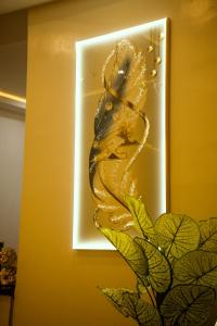 a lightswitch with a gold snake on a wall at Rex&Rich Hotel and Suites in Umu Oma
