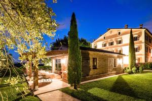 a house with a garden in front of a building at Poggio Antico in Monte San Vito