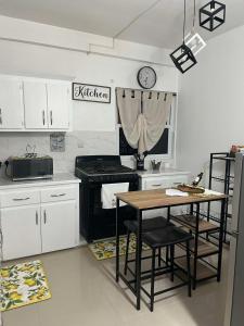 a kitchen with a table and a clock on the wall at Casa Bonita GLAM in Castries