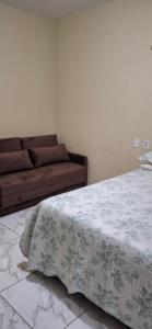 a living room with a bed and a couch at Casa Selma Ubajara in Ubajara