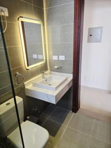 a bathroom with a sink and a toilet and a mirror at Luxury Azha Ain Sokhna Villa - Pool & Garden Views in Ain Sokhna