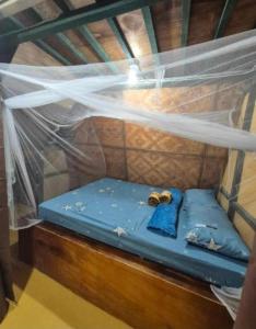 a bed in a small room with a net at Nirvana bamboo houses & dive centre in Moalboal