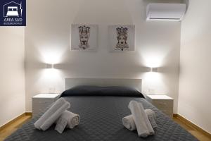ein Schlafzimmer mit einem Bett, auf dem zwei weiße Handtücher liegen in der Unterkunft Area Sud in Canicattì