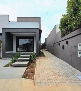 a house with a brick walkway next to a building at Studio moderno no centro de vinhedo in Vinhedo