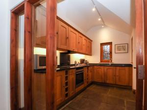 a large kitchen with wooden cabinets and appliances at Owl Cottage in Woodbridge