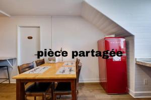 a dining room with a table and a red refrigerator at Chambre 306 de l'hôtel Victoria confortable et moderne in Saint-Pascal