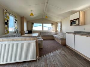 a caravan living room with a couch and a kitchen at The Rochester - Uk51003 in Eastchurch